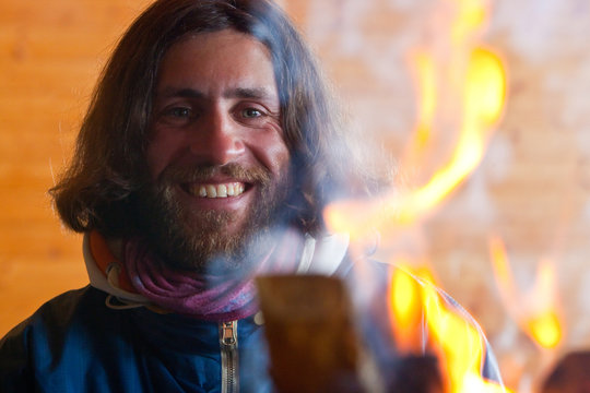 A man with long hair near a fire