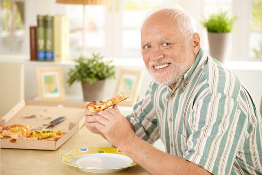 Portrait of senior having pizza