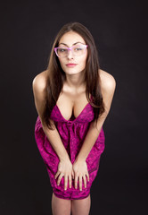Obraz premium Pretty young girl in red dress posing in studioon dark backgroun
