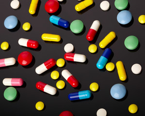 Colorful pills over dark background