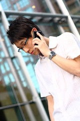 young businessman in a suit holding mobile phone in front of mod