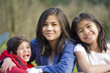 Two sisters and their disabled little brother at the park,