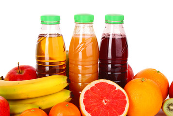 bottles of juice  with ripe fruits on white background
