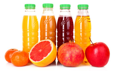 bottles of juice  with ripe fruits on white background