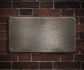 grunge metal plate with rivets on brick wall background