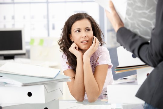 Young secretary sitting shocked in office
