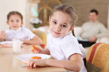 a  little girl at home having meal