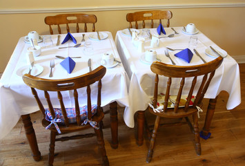 Small, cozy restaurant, beautifully decorated table with cutlery