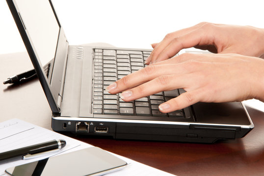 Hands typing on laptop computer keyboard