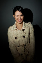 woman wearing a trench coat and smiling