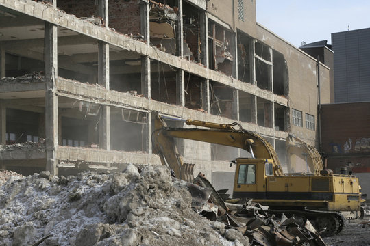 Demolition crew taking down concrete building