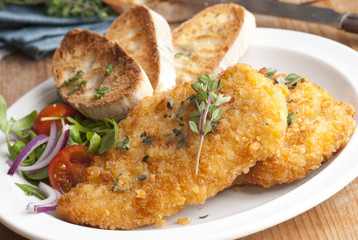 Pork schnitzels with toasts and salad
