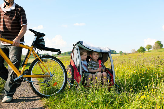 Familie fährt Fahrrad im Sommer mit Anhänger