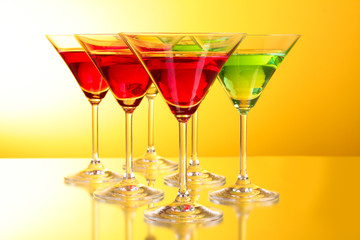 a few glasses of alcoholic drinks in a yellow-brown background