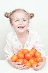 Little girl with orange mandarins