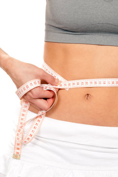 Athletic fit slim woman measuring her waist