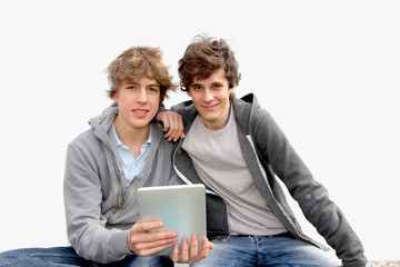 Teenage boys sitting outside with electronic tablet