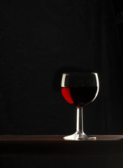 bicchiere di vino rosso su fondo nero