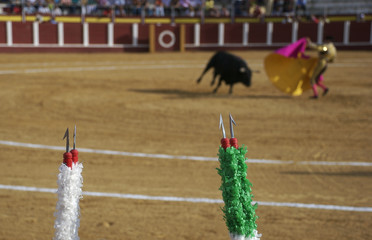 Bullfight, Banderillas in fore ground, Fuzzy background of Bullfight behind.