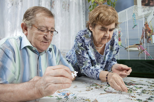 Senior couple working on a puzzle - Powered by Adobe