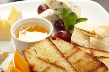 Cheese plate with grapes and honey
