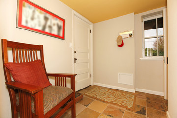 Mud room in the basement with nice chair.