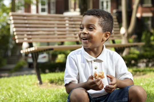 Young boy eating at a park