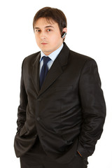 Businessman with headset keeping his hands in pockets