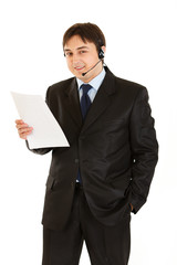 Smiling businessman with headset holding document in hand