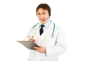 Smiling medical doctor with headset holding clipboard in hand