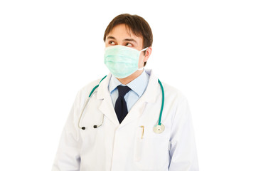 Medical doctor in mask  looking up at copy space