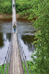 People on the old wood bridge over river.