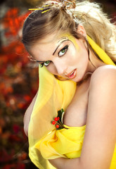 Naklejka premium Young beautiful girl in a yellow dress in the woods