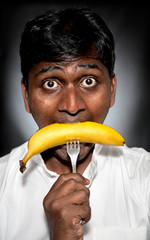 Indian man eating banana