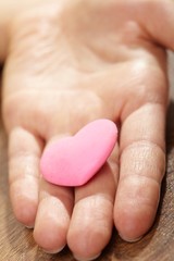 Woman holding pink heart in the hand