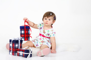 Naklejka premium little girl sits with three gift boxes.