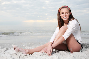 Girl with long hair enjoys summer day at the beach.