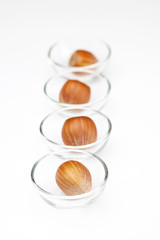 Nuts in miniature glass bowls isolated on white