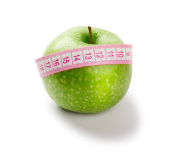 Green apple and measuring tape of the tailor isolated on white