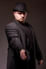 Man in black suite with gun.
