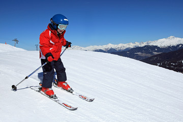 Fototapeta na wymiar Sporty zimowe: Mały narciarz na stoku (5 lat)
