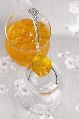 orange thin cut marmalade or jam on a spoon in a jar, shallow DO