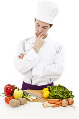A handsome man, chef thinking what to cook. Ingredients on table