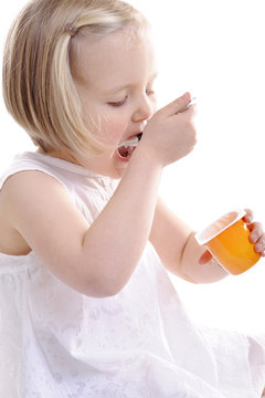 little girl eating yogurt, mouth wide open