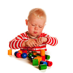 Fototapeta na wymiar Little boy playing with beads