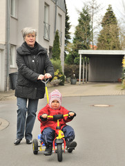 Oma und Enkelin mit Dreirad