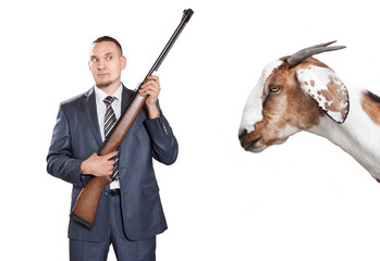 Businessman with gun looking at goat