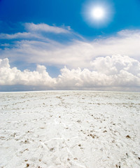 white salt desert under blue sky with clouds