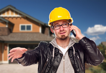 Contractor Wearing Hard Hat on Phone In Front of House