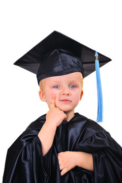 Cute little boy in graduation gown thinking